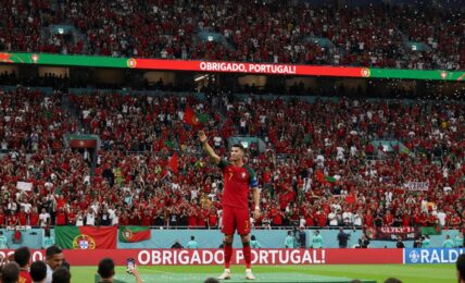 Il calciatore Cristiano Ronaldo saluta il pubblico sugli spalti di uno stadio gremito di tifosi.