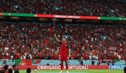 Il calciatore Cristiano Ronaldo saluta il pubblico sugli spalti di uno stadio gremito di tifosi.
